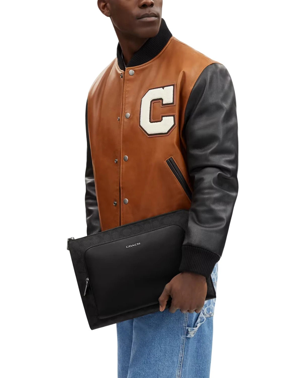 Man carrying the Coach Ethan Portfolio in Signature Canvas CU113 under his arm, styled for the office and business travel