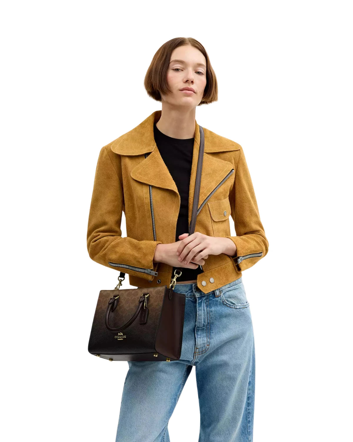 Woman wearing the Coach Maggie Small Tote Bag in Ombre Signature Canvas CDY27 on her shoulder using the detachable crossbody strap, styled for everyday wear
