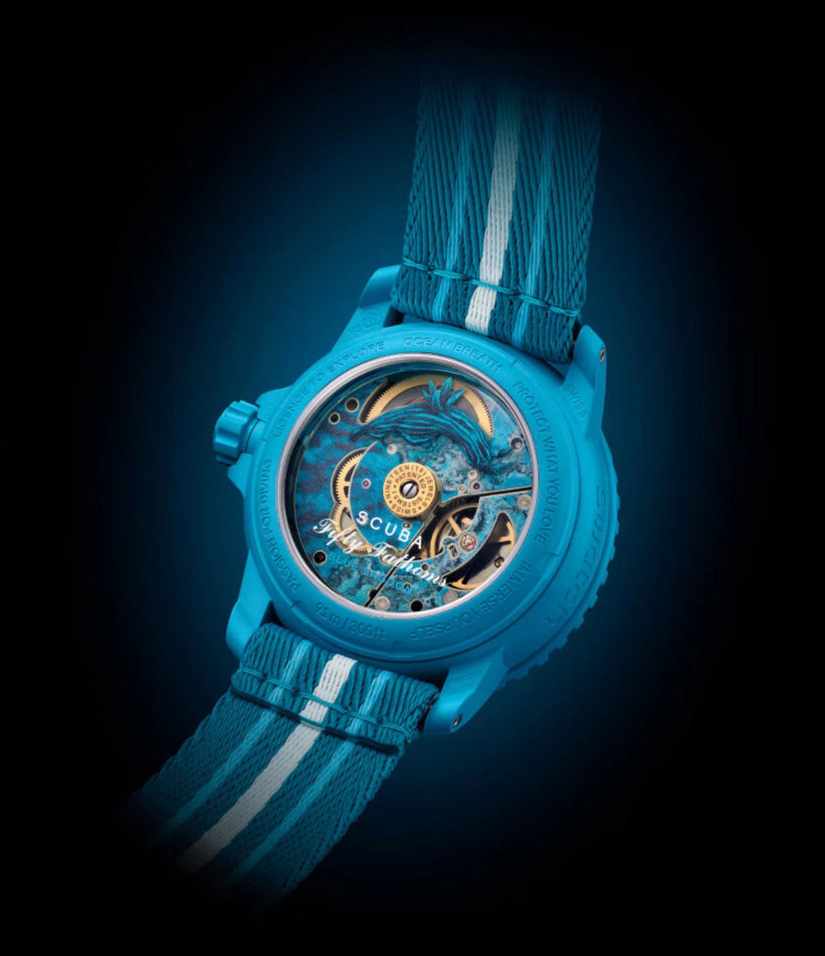 Transparent sapphire caseback of the Blancpain X Swatch Blue Lagoon SO35L400 showing the SISTEM51 mechanical movement with lagoon illustration and Tambja Mullineri nudibranch print
