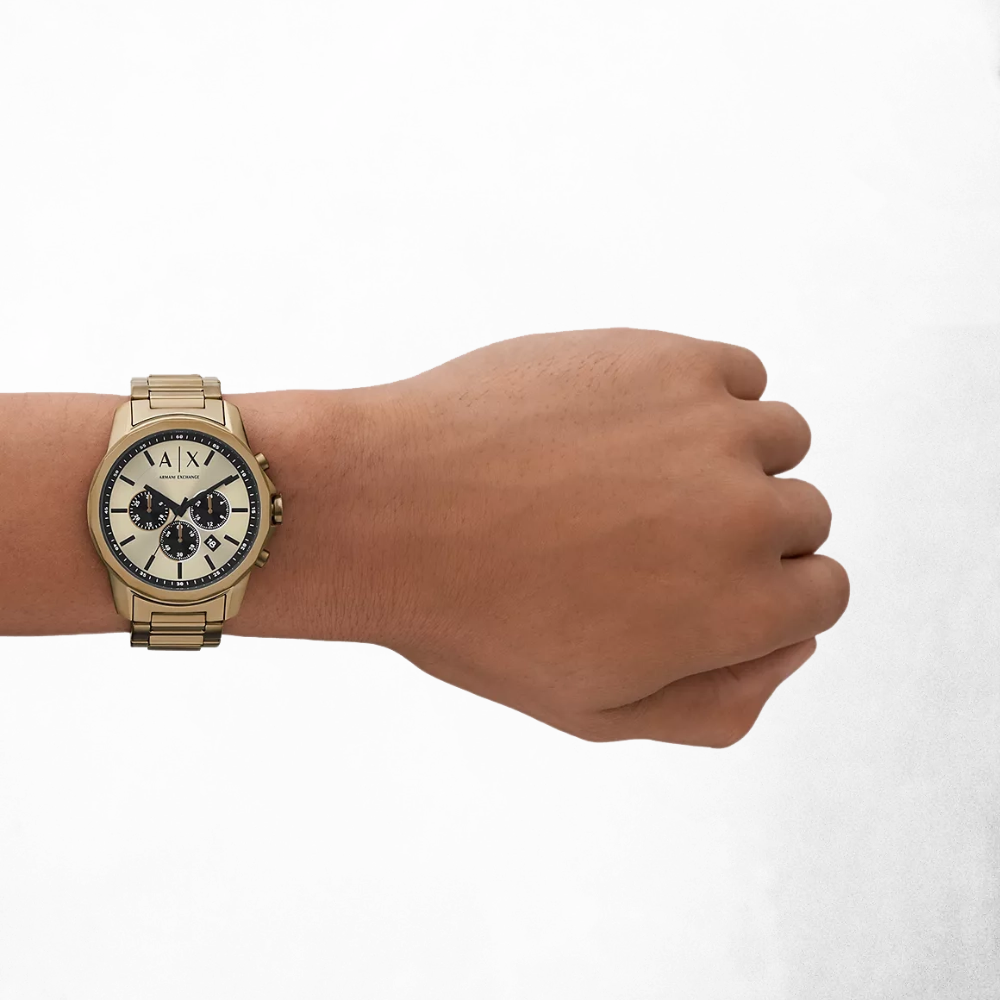Close-up of a man's hand a few inches above the wrist wearing the Armani Exchange AX1739 bronze gold-tone watch, highlighting its refined beige dial and metallic finish.