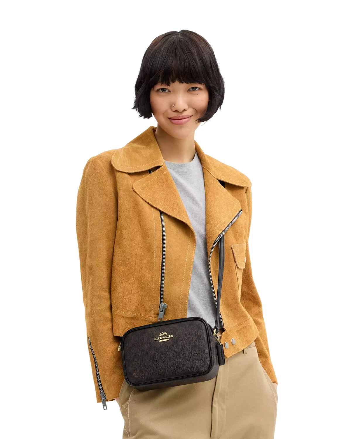 Woman wearing the Coach Mini Jamie Camera Bag in Signature Canvas CY752 as a crossbody, styled for a casual everyday look