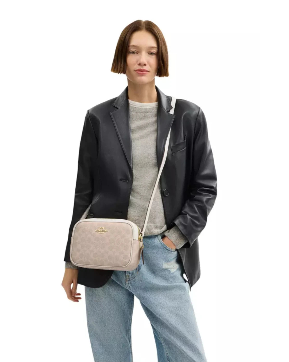 Model wearing the Coach Jamie Camera Bag in Signature Canvas as a crossbody, styled for an elegant everyday luxury look.