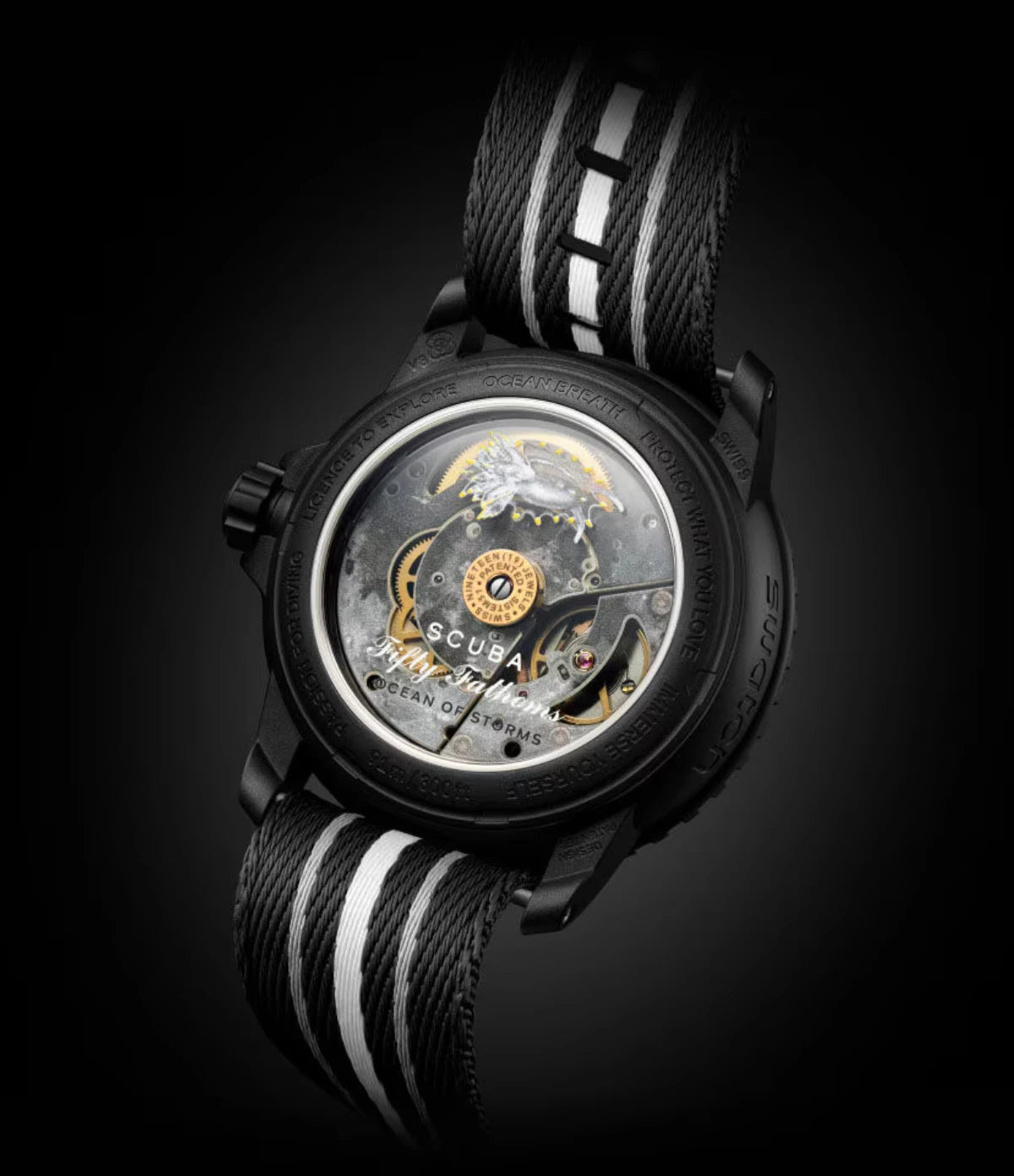 Transparent sapphire caseback of the Blancpain X Swatch Ocean of Storms SO35B400 showing the SISTEM51 mechanical movement with lunar Oceanus Procellarum illustration and Okenia Luna nudibranch print