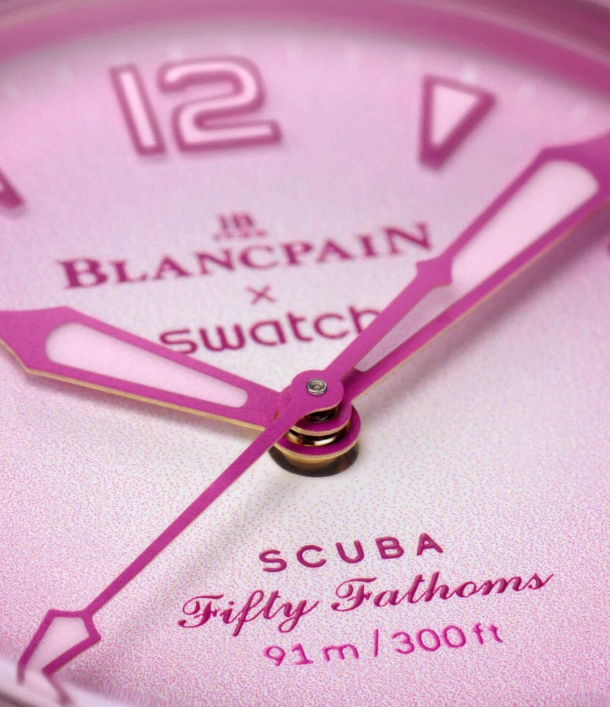Close-up of the Blancpain X Swatch Pink Ocean SO35P400 gradient pink dial showing Super-LumiNova hour indexes and hands
