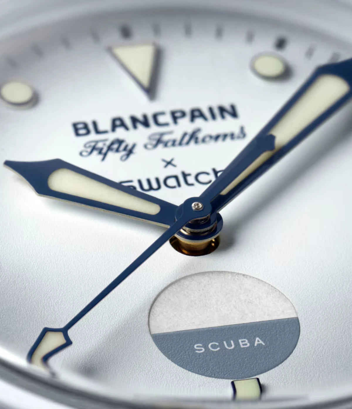 Close-up of the Blancpain X Swatch Antarctic Ocean SO35S100 gradient ice-white dial showing Super-LumiNova hour indexes and hands