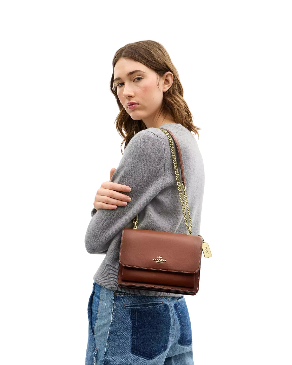 Woman wearing the Coach Klare Crossbody Bag CDY35 in redwood burnished leather, styled crossbody for an everyday casual look