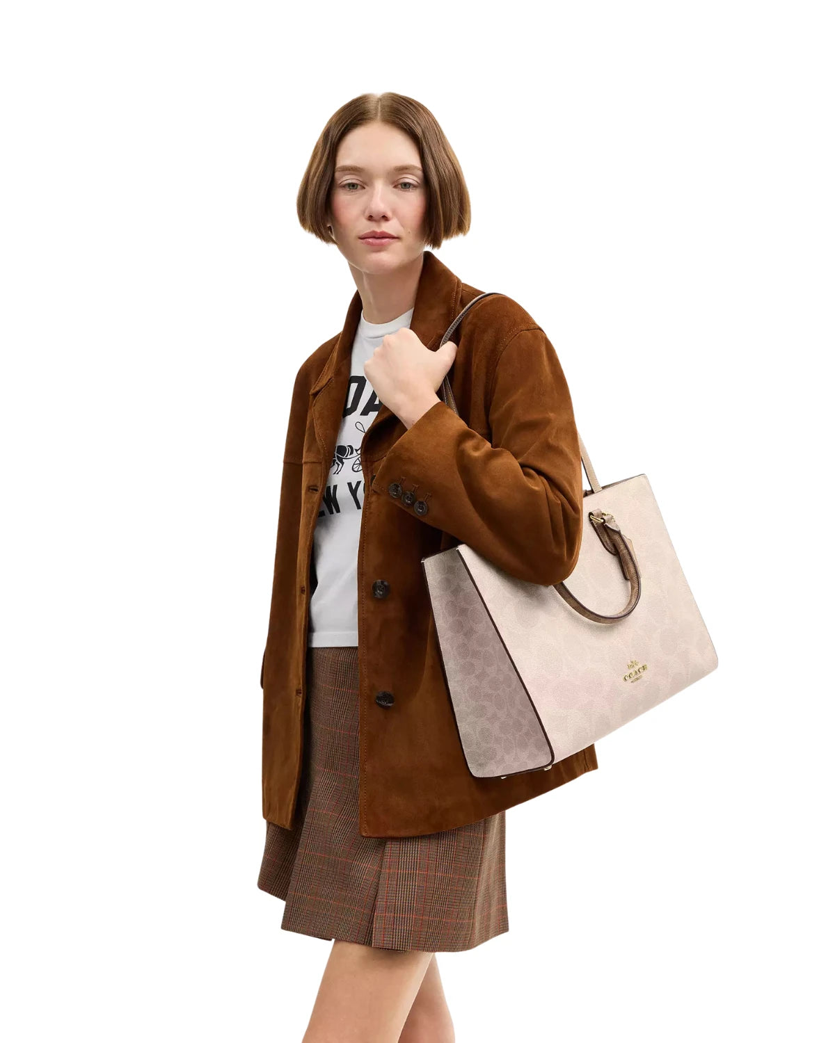 Woman carrying the Coach Maggie Tote Bag in Blocked Signature Canvas CY677 on her shoulder, styled for work and weekend errands