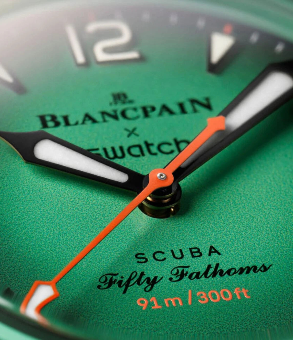 Close-up of the Blancpain X Swatch Indian Ocean SO35I100C gradient green dial showing Super-LumiNova hour indexes and hands