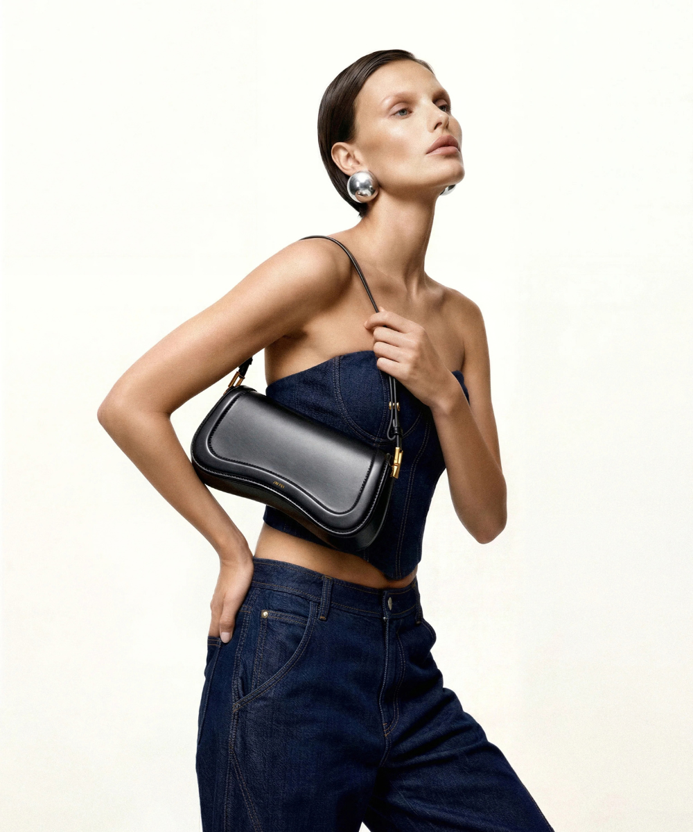 Lifestyle view of the JW PEI Joy black bag styled for shoulder / crossbody wear